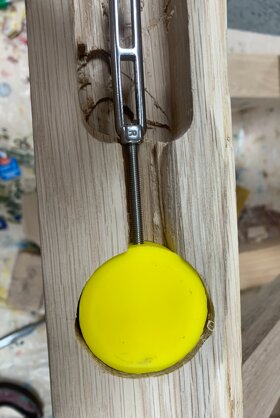 Brass puck anchor set into the oak